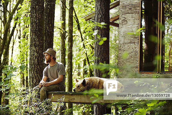 Mann mit Hund auf der Veranda sitzend