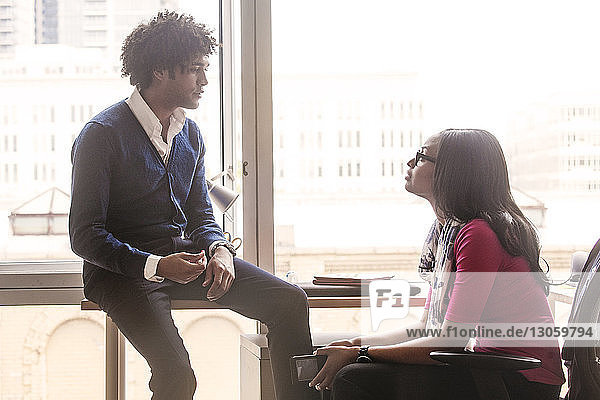 Businessman and businesswoman discussing in office