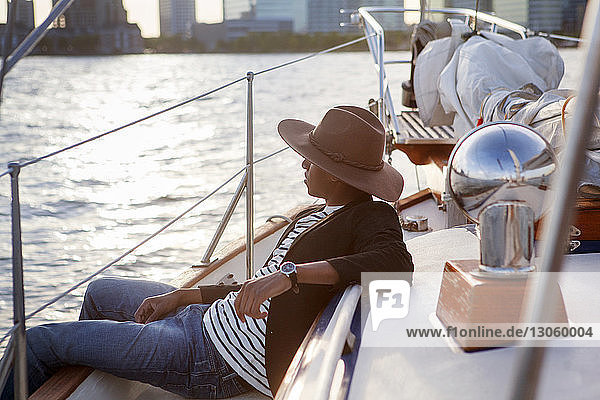 Side view of man with cowboy hat sitting on yacht