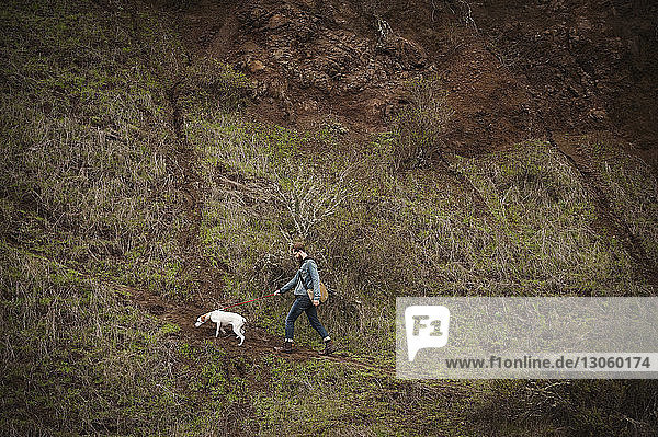 Mann mit Hund beim Waldspaziergang