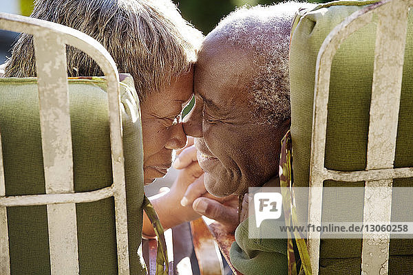 Älteres Ehepaar reibt sich die Nase  während es auf Stühlen sitzt