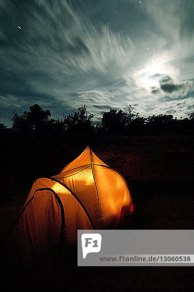 Beleuchtetes Zelt im Wald bei Nacht