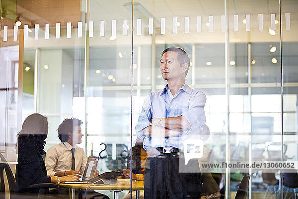Business people working in office seen through glass