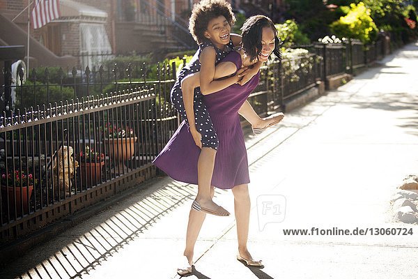 Daughter getting piggyback ride from her mom