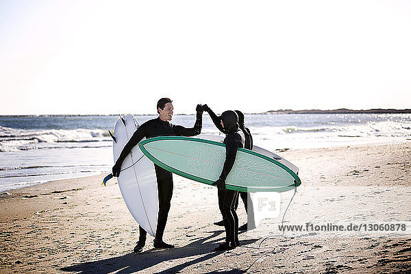Surfer  die am Strand stehend einen Faustschlag machen