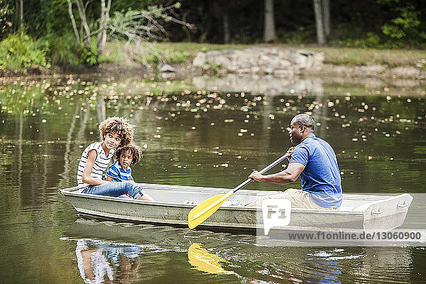Vater und Kinder beim Bootfahren auf dem See