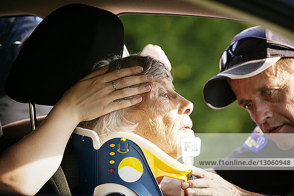 Nahaufnahme eines Sanitäters beim Anlegen einer Halskrause an einen Patienten im Auto