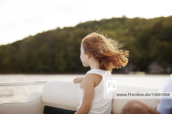 Mädchen betrachtet Aussicht  während sie im Boot auf dem See sitzt