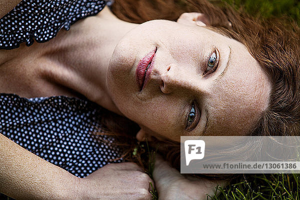 Portrait of woman lying on field
