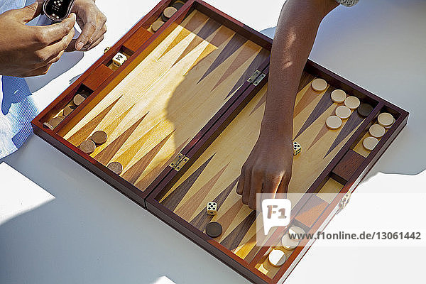 Ausgeschnittenes Bild eines Backgammon spielenden Paares zu Hause