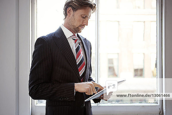 Geschäftsmann mit Tablet-Computer im Stehen im Büro