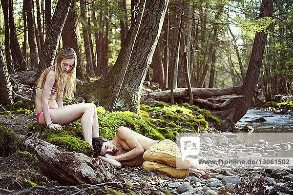 Ehepaar entspannt sich am Flussufer im Wald
