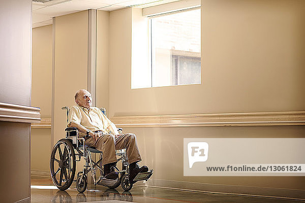 Auf Rollstuhl sitzender Mann im Korridor