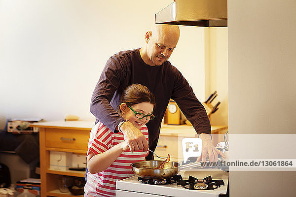 Vater und Tochter kochen Essen in der Küche