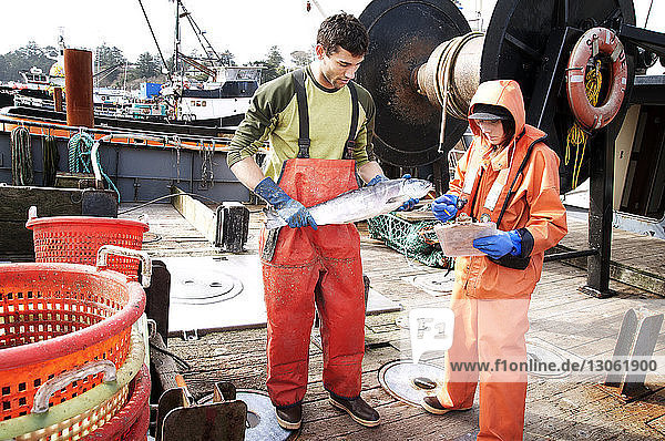 Mann und Frau kontrollieren Fische auf Fischerbooten