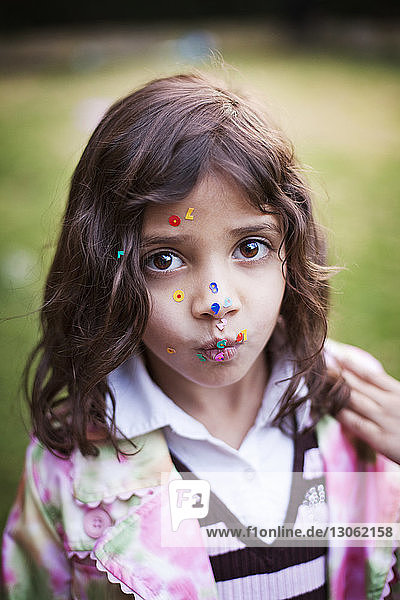 Porträt eines Mädchens mit Aufklebern im Gesicht