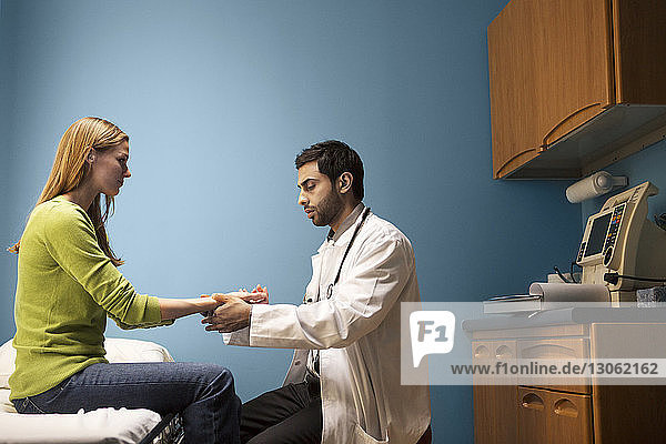Arzt kontrolliert den Puls einer Frau im Krankenhaus