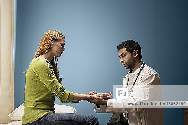Doctor checking pulse of patient in hospital