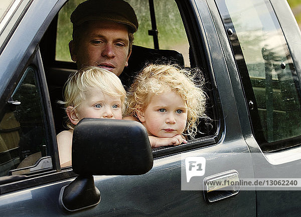 Vater mit Kindern im Kleintransporter