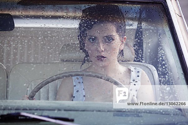 Bildnis einer Frau mit kurzen Haaren im Auto sitzend
