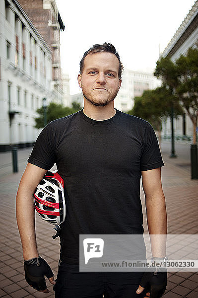 Portrait of man with cycling helmet standing outdoors