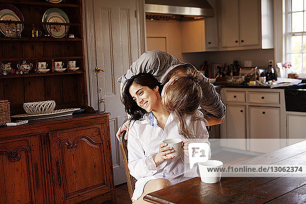 Man kissing girlfriend in kitchen