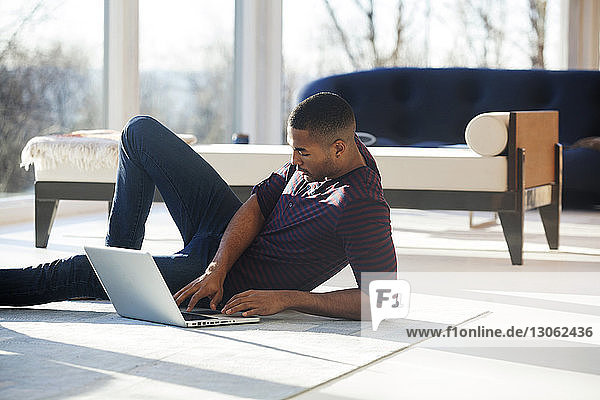 Mann arbeitet am Laptop  während er zu Hause sitzt