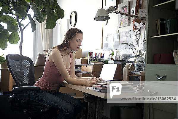 Seitenansicht einer am Schreibtisch arbeitenden Frau
