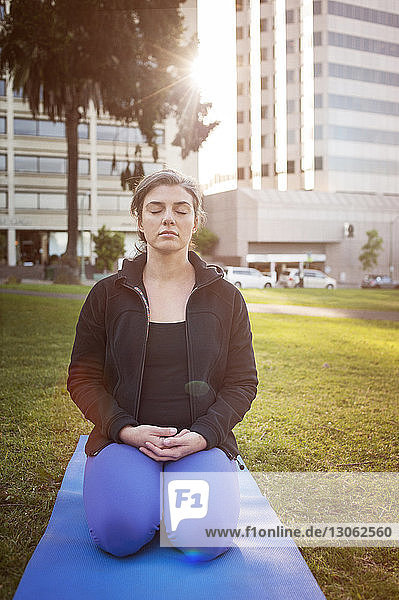 Frau meditiert im Park