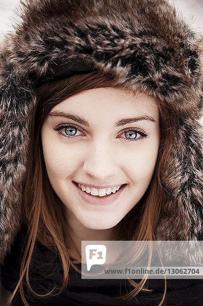 Close-up portrait of happy woman wearing fur hat