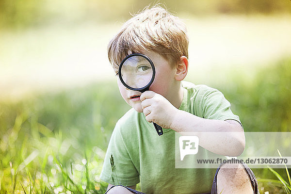 Portrait of boy looking through magnifying glass