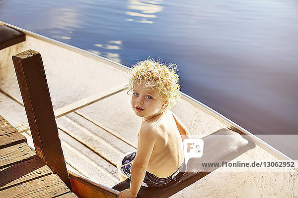 Hochwinkelaufnahme eines Jungen  der im Boot auf dem See sitzt