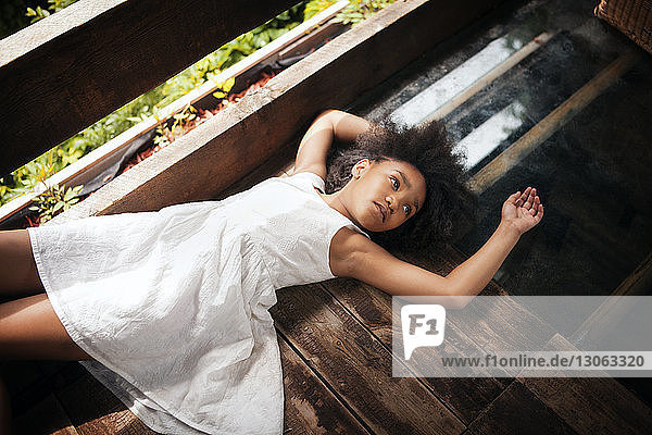 Hochwinkelansicht eines auf dem Boden liegenden Mädchens im Baumhaus