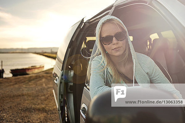 Woman looking through window while sitting in car