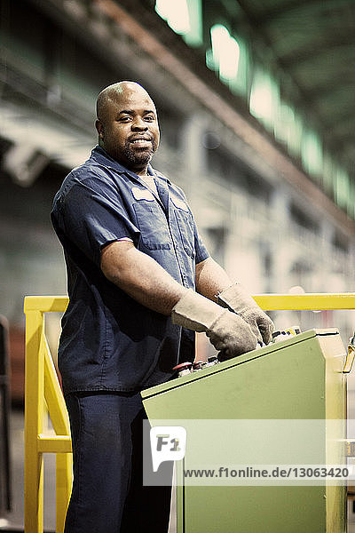Porträt eines Mannes,  der in der Metallindustrie Maschinen bedient