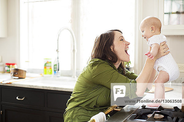 Happy mother playing with baby girl in bathroom