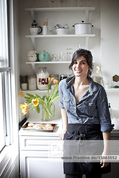 Porträt einer Frau  die zu Hause an der Küchentheke steht