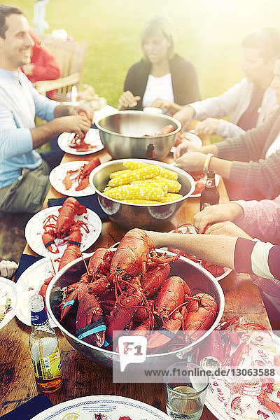 High angle view of friends eating lobsters at table