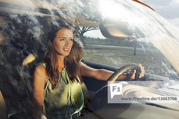 Woman looking away while driving car