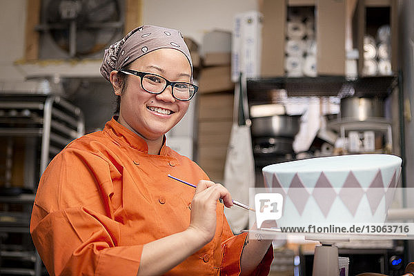 Portrait of woman decorating cake at store
