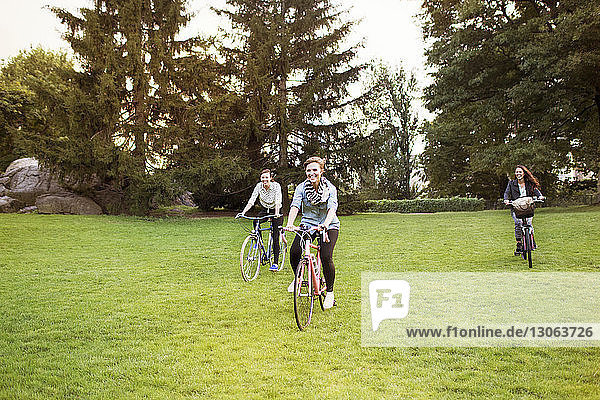 Happy female friends cycling in Central Park