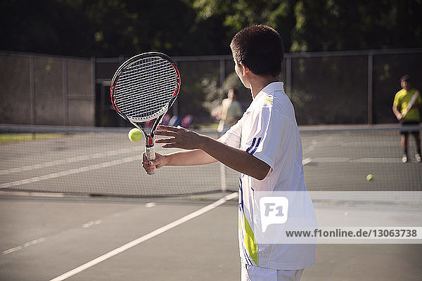 Spieler  die Tennis auf dem Platz gegen den Zaun spielen