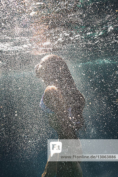 Seitenansicht einer unter Wasser schwimmenden Frau