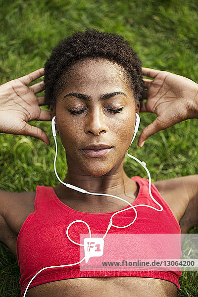 Hochwinkelansicht einer Frau  die während einer Übung vor Ort Musik hört