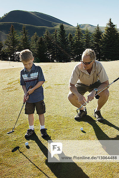 Großvater unterrichtet Golf für Jungen