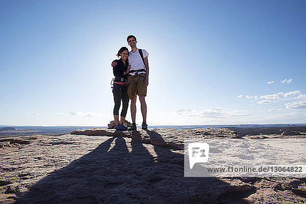 Portrait of happy couple standing on mountain against sky
