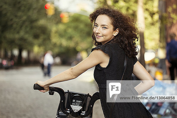 Portrait of woman with bicycle on road