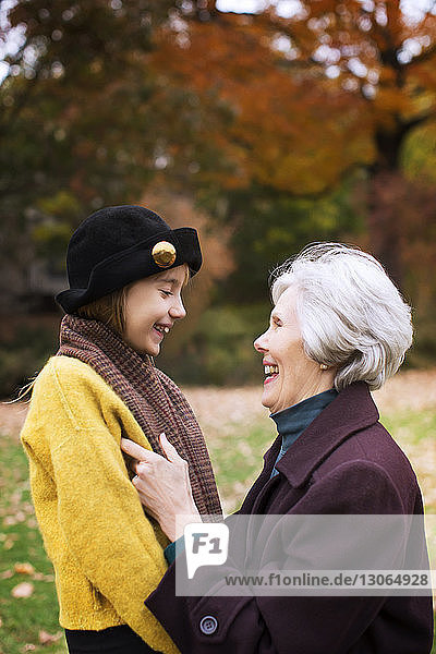 Großmutter und Enkelin sehen sich im Park an und lächeln