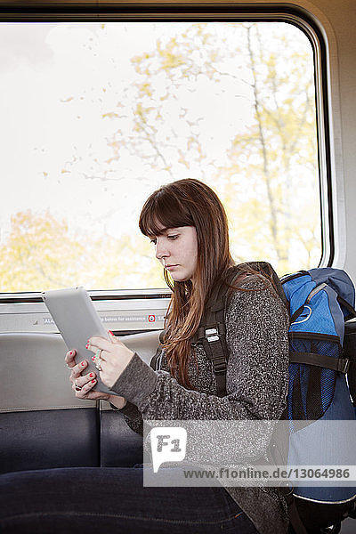 Frau benutzt Tablet-Computer  während sie im Zug sitzt
