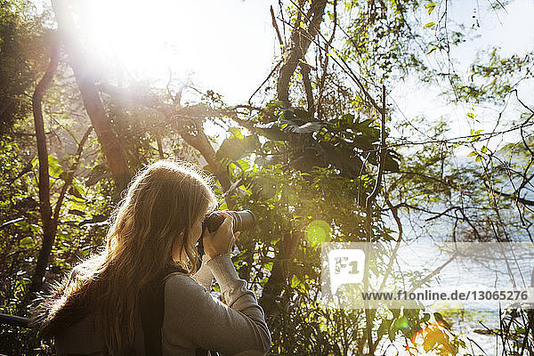Frau fotografiert im Wald stehend